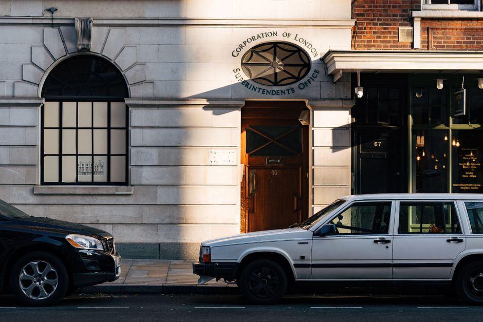 A street view of the Superintendent's Office in London with parked cars and architectural details.