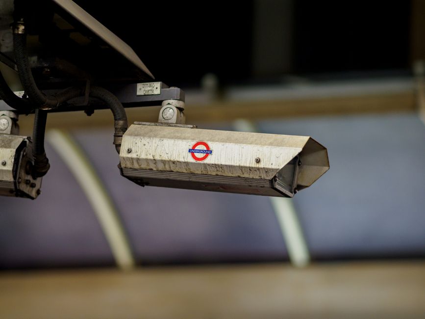 Close-up of a CCTV camera installed at a London Underground station for security surveillance.